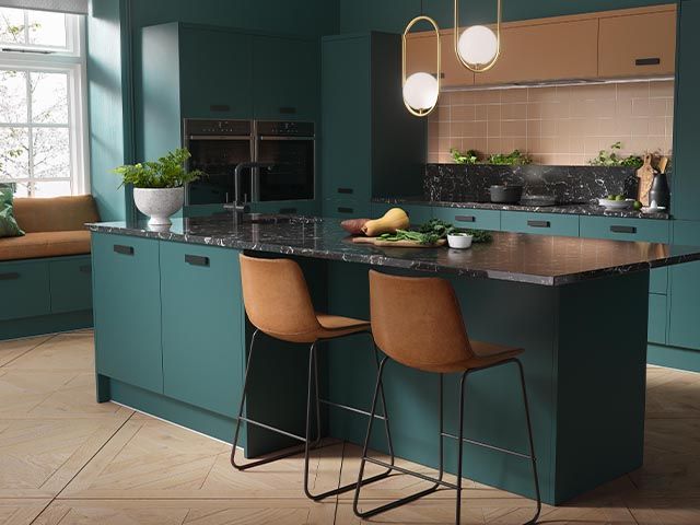 dark green kitchen cabinets with tan bar stools and pink tiles