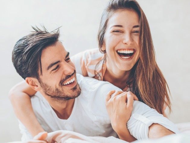 man and woman laughing and cuddling copy