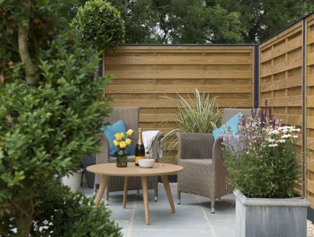 outdoor table chairs and planters with wooden fences