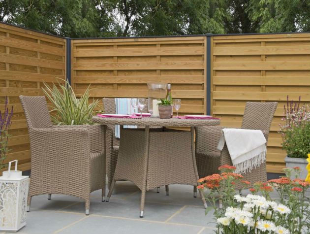 table and chairs on outdoor patio with wooden fencing behind