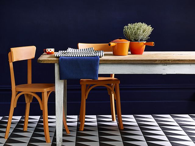 dark blue kitchen with orange accents - goodhomesmagazine.com