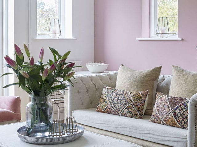 Buttoned sofa and armchair with cut lilies in pink living room, Tunbridge Wells home, Kent, UK. Image: Brent Darby/Narratives