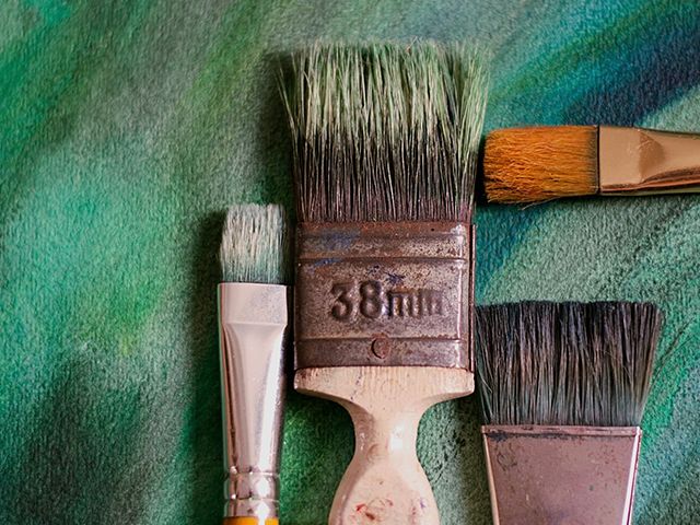 paintbrushes on flatlay surface - how to successfully paint your front door - inspiration - goodhomesmagazine.com