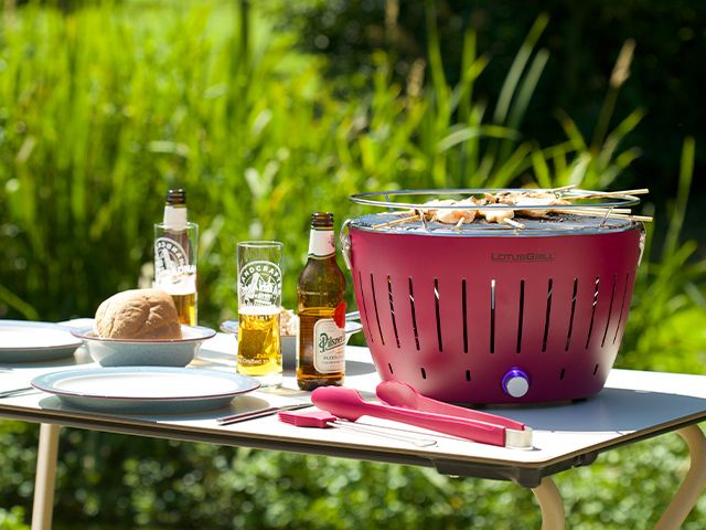 red tabletop bbq with beer - 6 of the best BBQs for small gardens - garden - goodhomesmagazine.com
