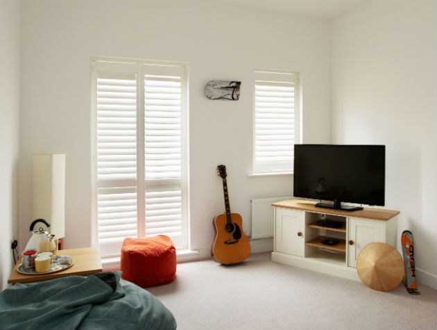 white room with beanbags tv guitar and shutters