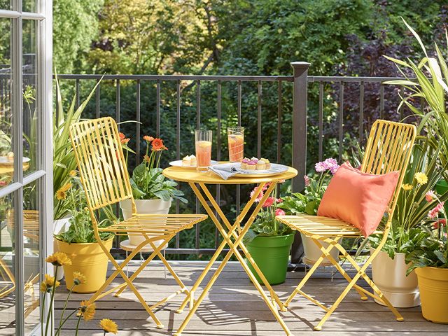 yellow bistro set on balcony - how to style a balcony area - garden - goodhomesmagazine.com