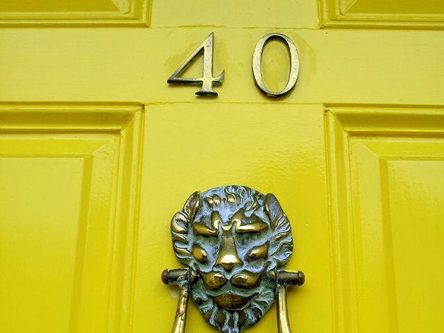 yellow door number and lion knocker - how to successfully paint your front door - inspiration - goodhomesmagazine.com