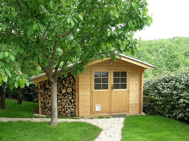 garden shed with log store and trees in large garden