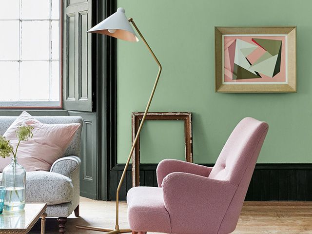 green painted living room with pink armchair - goodhomesmagazine.com