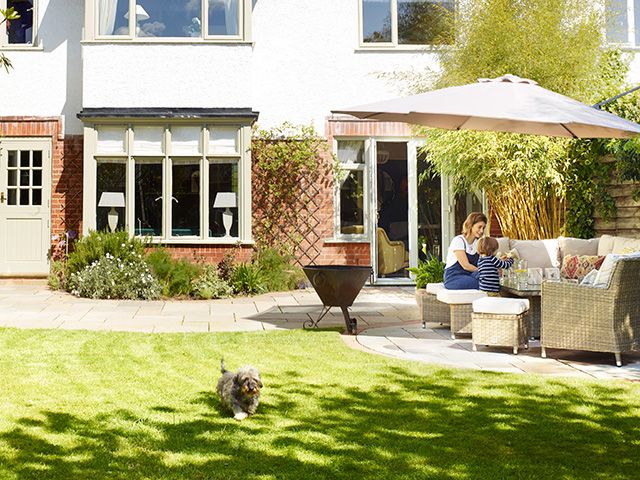 garden with paved patio outside house - goodhomesmagazine.com