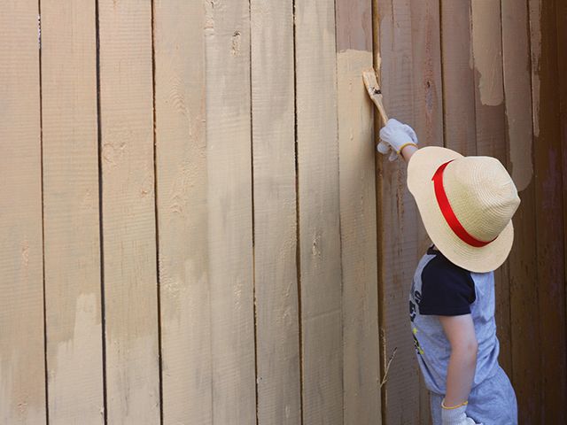 painting fence - top tips for making a small garden look bigger - garden - goodhomesmagazine.com
