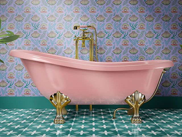 colourful home decor: pink roll top bath with gold feet, lilac printed wallpaper and green patterned tiles