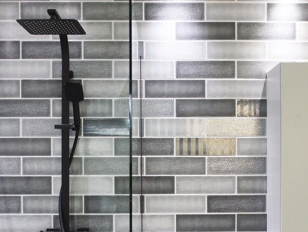 shower and sink with black and grey tiles