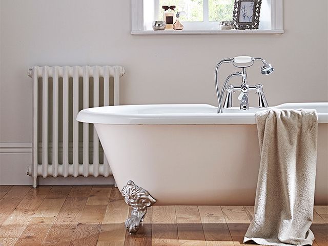 white bathroom ideas - wooden flooring with freestanding white tub with silver claw feet