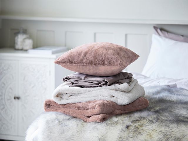 bedroom pile of throws - 6 ways to update your bedroom for autumn - bedroom - goodhomesmagazine.com