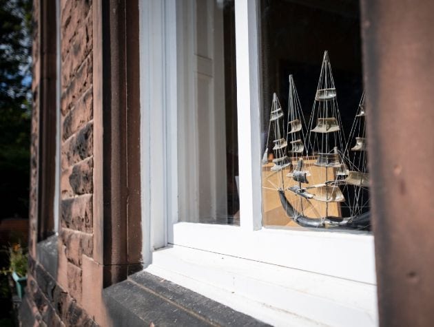 close up detail of sash window with model ship inside