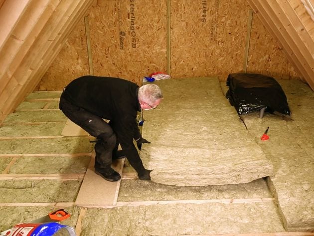man laying insulation in loft space