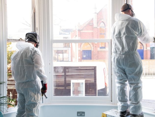 two men in protective clothing installing sash windows