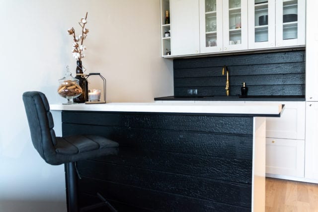 sink, cupboards and island in kitchen area with black timber