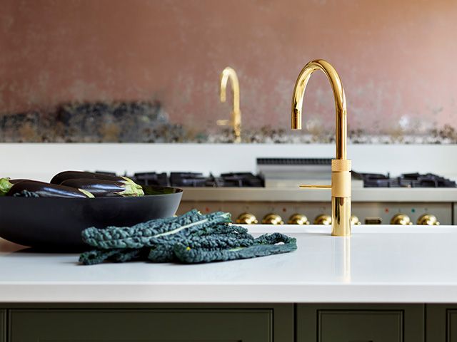 shiny brass kitchen hot tap in pink and green kitchen - goodhomesmagazine.com