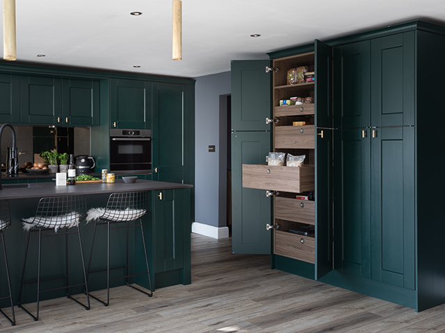 kitchen with dark green cabinets, chairs and pull out drawers