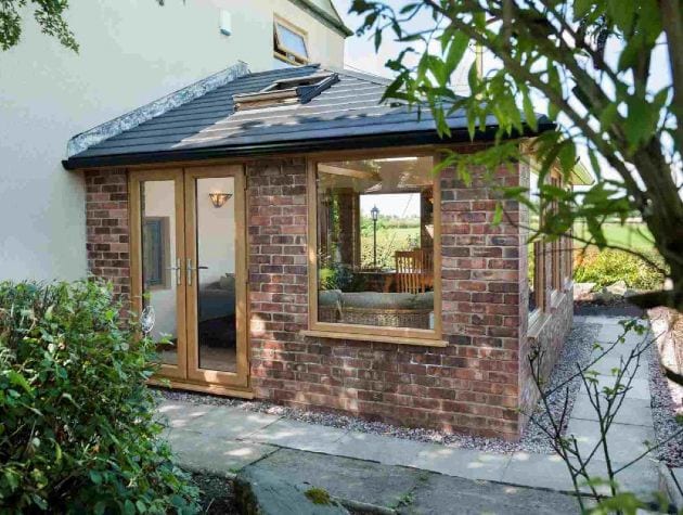 conservatory with solid roof and brown wood window frames