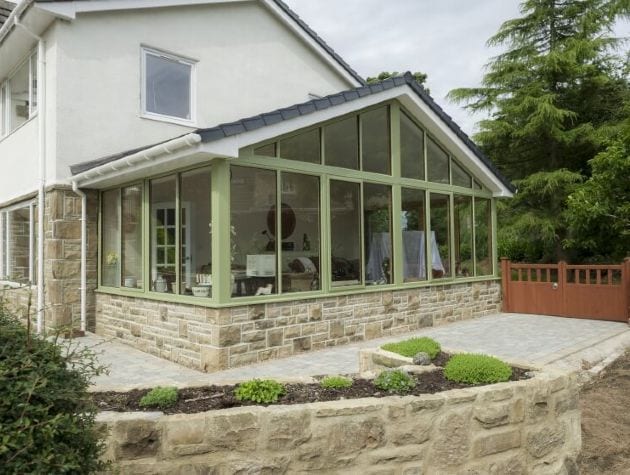 house with conservatory with green window frames