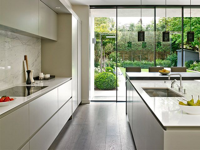 modern handless kitchen with marble-effect splashback and sliding glass doors