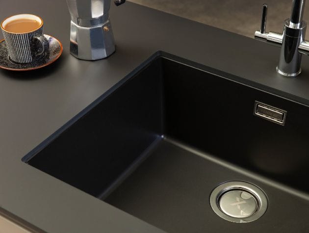 top down view of a black sink and worktop with coffee