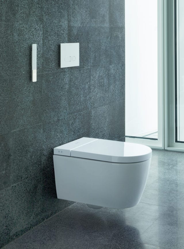 wall-mounted toilet with grey tiled wall and floors