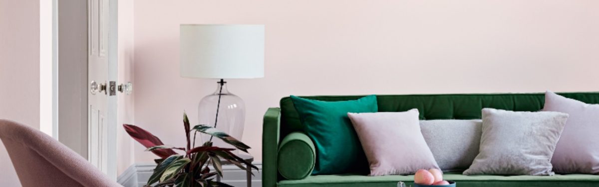 room with pink walls, green sofa, coffee table and pink chair