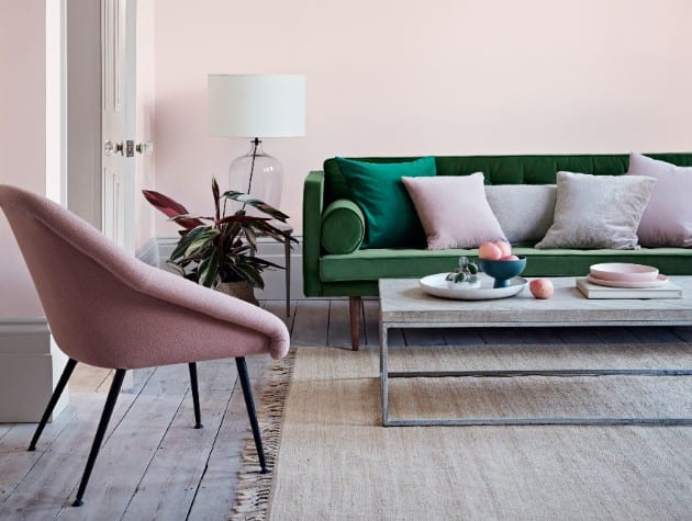 room with pink walls, green sofa, coffee table and pink chair