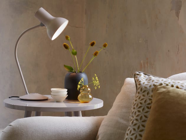 white anglepoise lamp on table next to sofa