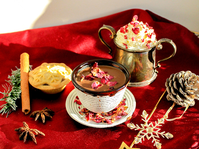 A mug of Turkish Delight Espresso Hot Chocolate topped with candied rose petals