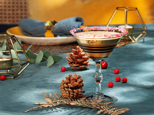 A martini glass filled with GREY GOOSE® Candy Cane Lane cocktail, and garnished with crushed candy canes