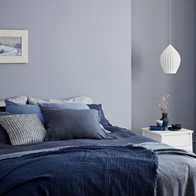 bedroom painted blue, bed with covers in various blue shades