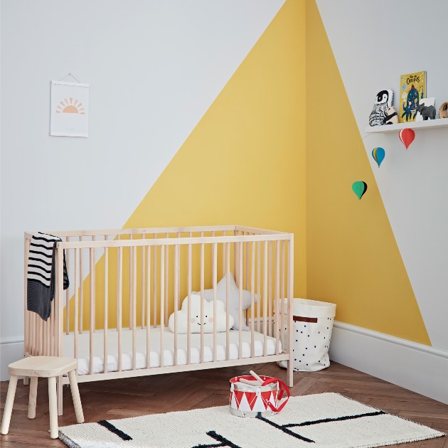 child’s bedroom with wooden cot, yellow and white painted wall