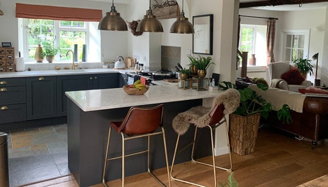 kitchen with grey cabinets and marble worktop, seats and pendant lighting