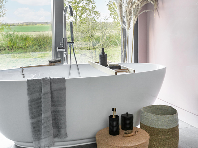 minimalist bathscaoe ideas: pale pink bathroom wall, natural materials and cocoon bath