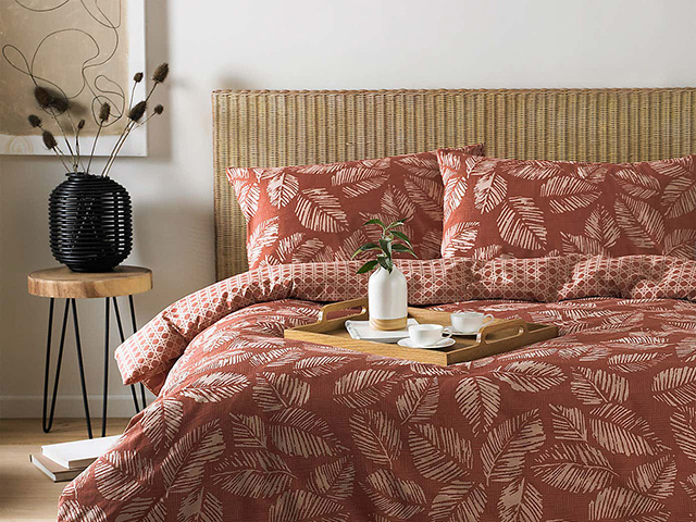 red japanese inspired bedding on wicker bed - japandi interiors trend - goodhomesmagazine.com