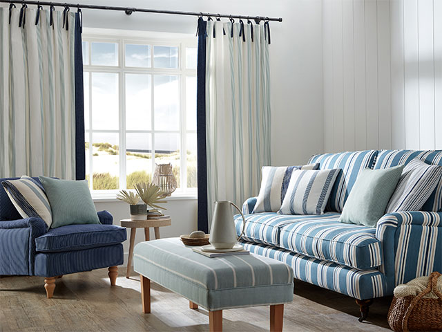 coastal grandma living room with blue and white striped sofa and white wall panels