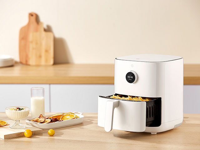 Smart air fryer kitchen gadgets on wooden kitchen worksurface