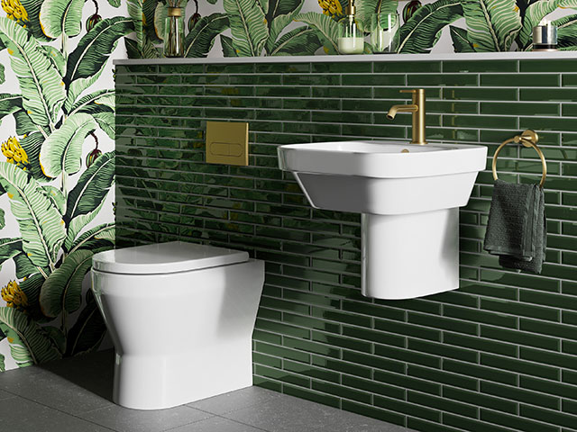 Green tiles in bathroom with leafy wallpaper