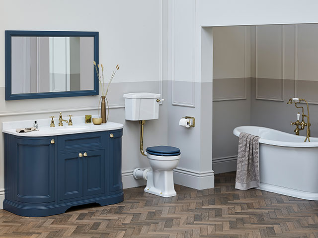 Blue rounded bathroom units with laminate floor and grey and white panelled wall