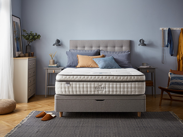 Premium mattress in a blue bedroom with grey bed frame 