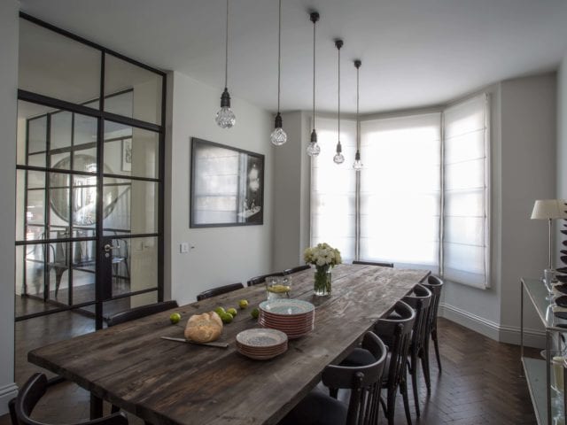 large dining table and chairs, pendant lighting, bay window and crittall-style doors