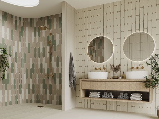 lozenge-shaped bathroom tiles in white, green and sand colour in a curved walk-in shower with gold shower fitting