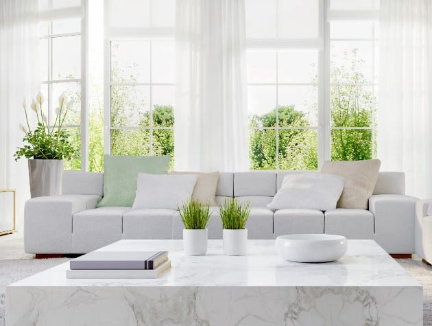 open plan living area with white sofas, kitchen and windows