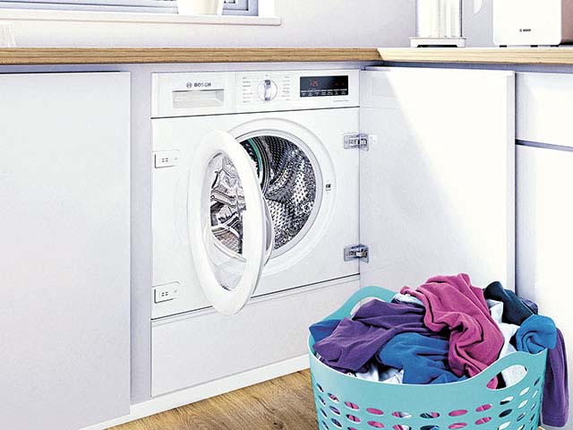 Bosch quiet washing machines built in with pile of laundry in front
