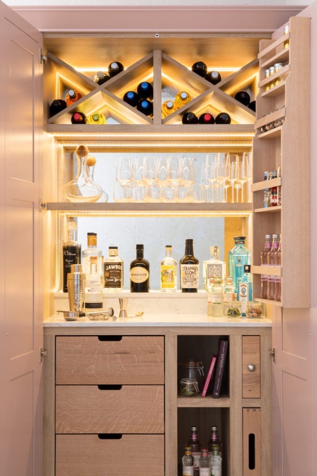 drinks cabinet with glasses, gin and wine bottles